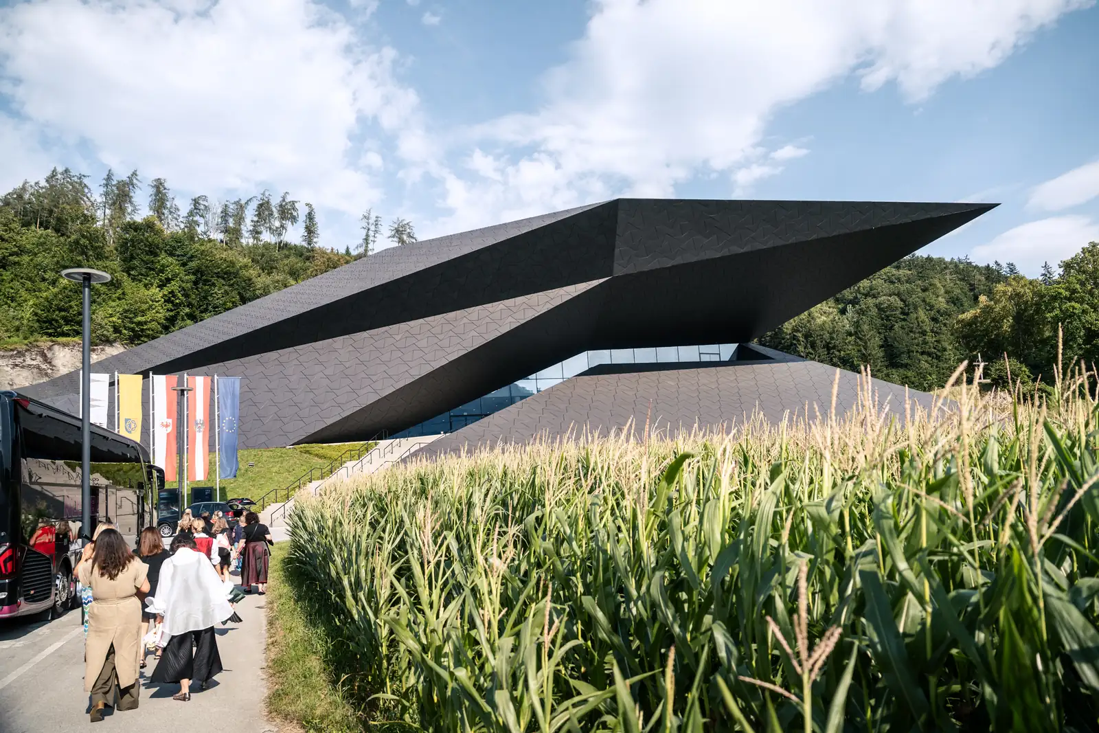 Festspielhaus Erl im Kufsteinerland Besucherinnen vor dem Festspielhaus Erl neben einem Maisfeld