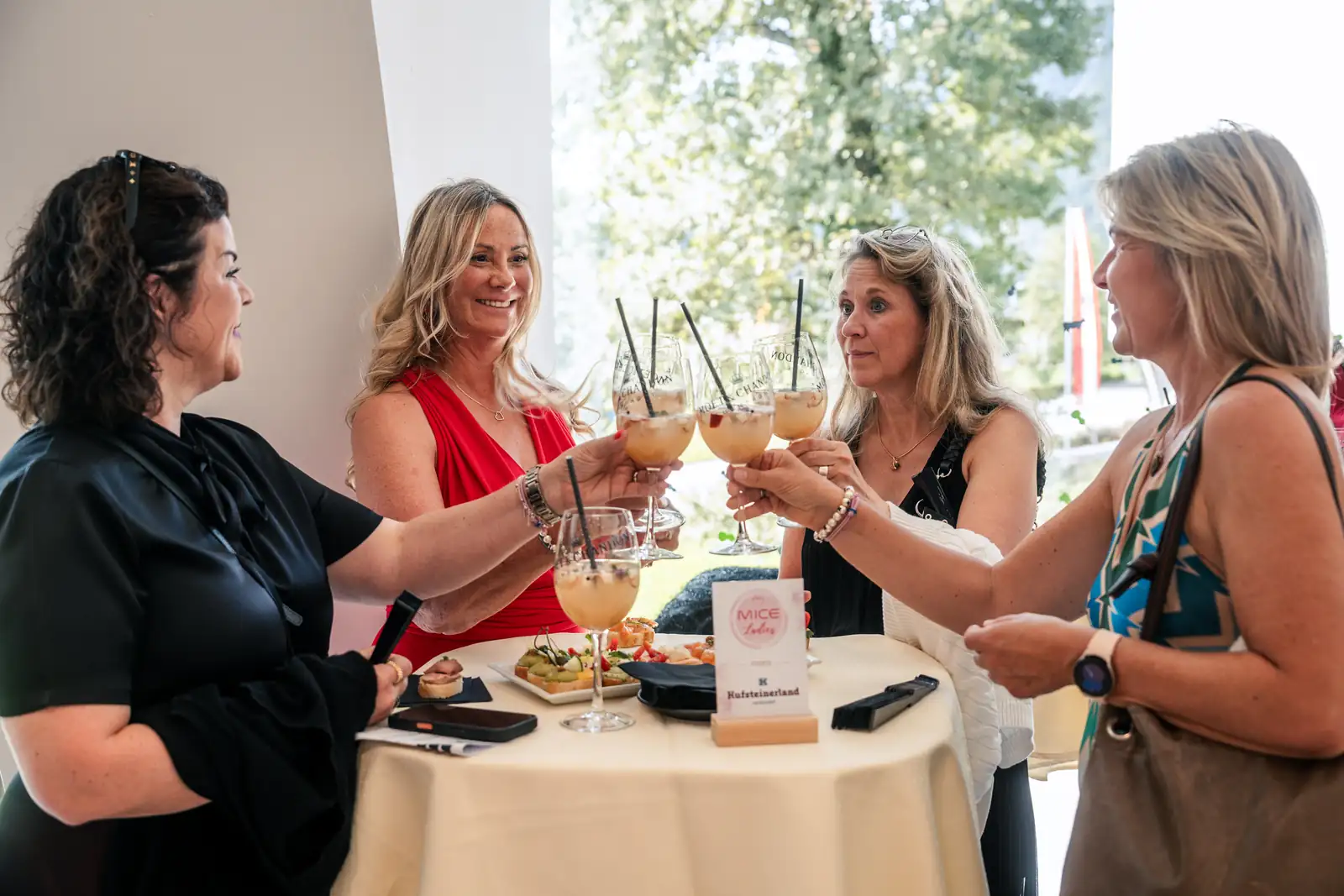 Networking der MICE Ladies im Festspielhaus Erl Vier Teilnehmerinnen stoßen bei einem Empfang im Festspielhaus Erl an