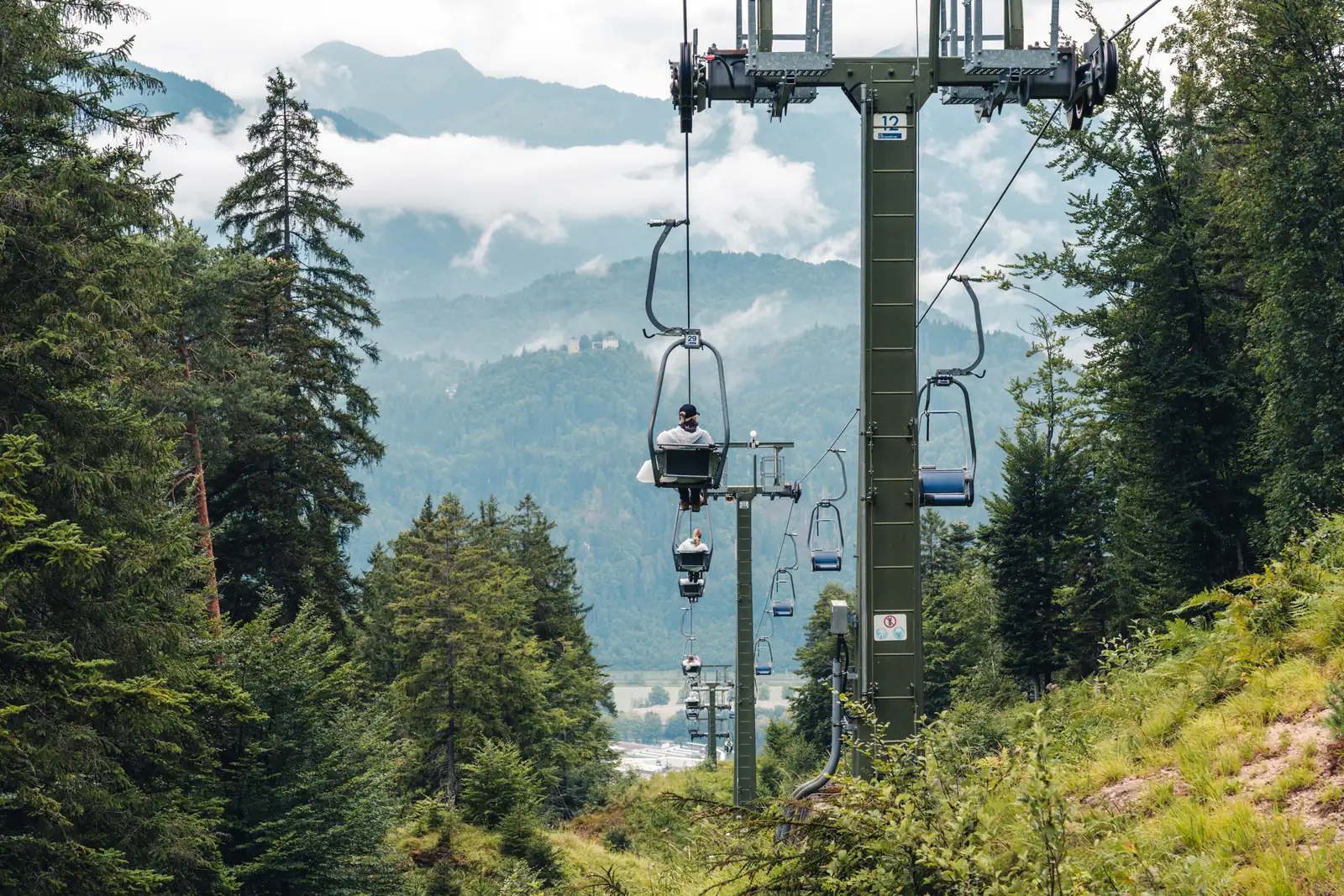 Historischer Kaiserlift Kufstein Teilnehmerin fährt im Einersessel des historischen Kaiserlifts