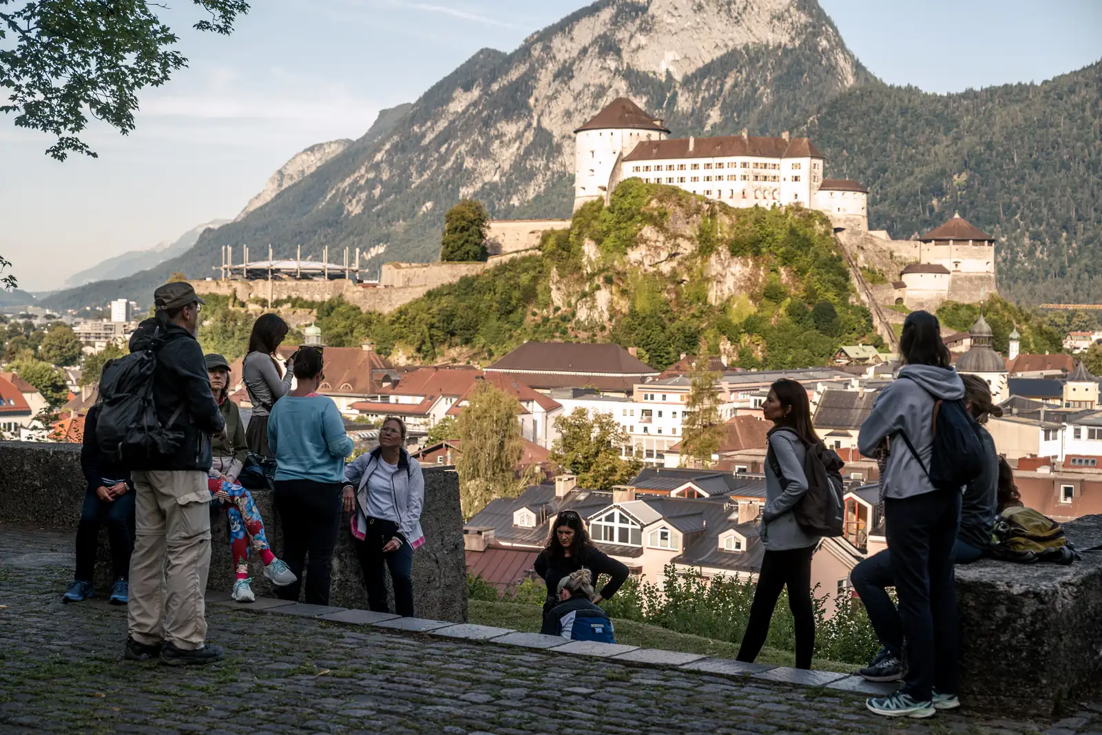 Wanderung mit Festungsblick in Kufstein Gruppe wandert auf einem sonnigen Waldweg mit Blick auf Kufstein
